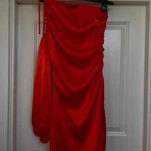 Klänning  - Använd vid 1 tillfälle  Kan passa en S One shoulder klänning  Snörningar upptill klänningen samt nertill därav kan man justera hur kort/lång man vill ha den 