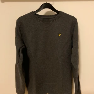 Lyle & Scott sweatshirt  - En mörkgrå Lyle & Scott sweatshirt i mycket bra skick. Den är använd men har inga defekter. Den är 14/15 years i storlek men passar som xs. Hör av er vid funderingar