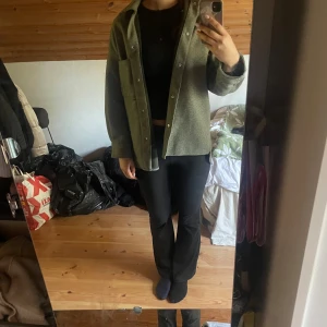 Grön overshirt från Zara - Säljer en snygg grön overshirt från Zara. Den har en normal passform och är perfekt för höst och vår. Jackan har långa ärmar och knappar framtill. Den är i bra skick och passar både till vardags och lite mer uppklädda tillfällen.