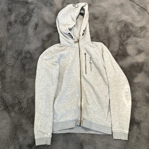 SailRacing Kofta - Koftan har lite defekter så som, fickan, på armen och små röda fläckar vid en ficka! Men inget som märks jättemycket!