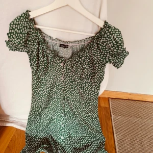 Grön Bohoo klänning 36 - Grön Boohoo klänning med vita blommor, sparsamt använd.