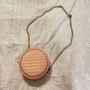 Rosa väska  - Rund rosa väska ifrån Lindex, använd sparsamt fåtal gånger, inga skador och kedjan är fortfarande guldig 