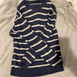 Randig tröja - En jätte fin mörkblå tröja med vita ränder. Den är min systers gamla så den har blivit använd men inga defekter eller fläckar. Säljer eftersom jag rensar garderoben och den inte blivit använd. 