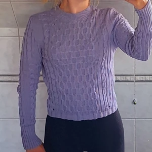 Lila stickad tröja - Säljer en superfin lila stickad tröja. Den är perfekt för höst och vinter, och den har ett snyggt mönster som gör den extra speciell. Tröjan är långärmad och har en normal passform. Den är i fint skick och väldigt mysig att ha på sig. Perfekt för både vardag och fest!