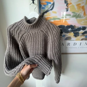 Beige stickad tröja - Säljer en supermysig beige stickad tröja. Den har en hög krage och långa ärmar, perfekt för kyliga dagar. Tröjan är i nyskick och passar perfekt till höst och vinter. Den är både stilren och bekväm, ett måste i garderoben!