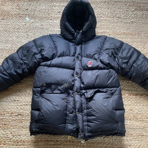 Fjällräven jacka - Säljer en svart, fluffig dunjacka från Fjällräven i storlek XXS men passar som XS/S. Jackan har huva, stora fickor med knappar och dragkedja samt klassisk Fjällräven-logga på bröstet. Perfekt för kalla dagar och riktigt skön att bära. Passformen är oversized och jackan är riktigt varm. Inga defekter. Priset går att diskuteras. 