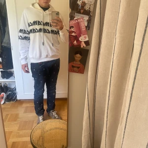 Alexander McQueen hoodie - Vit hoodie från Alexander McQueen med svart tryck i grafisk stil över bröstet och ärmarna. Tröjan har huva med snörning och är tillverkad i mjuk bomull. I mycket bra skick men en liten fläck på magen, går lätt att ta bort med vanish! Kostar sex tusen nypris, säljer den för 629kr! Hör av er om ni har några frågor eller funderingar!