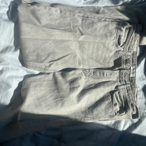 Grå loose fit jeans LOOSE/CHRIS - Snygga grå jeans i loose fit-modell från LOOSE/CHRIS. Jeansen har klassisk femficksdesign, bälteshällor och raka ben. Perfekt för dig som gillar en avslappnad och trendig look. Materialet är mjukt och slitstarkt denim. Storlek 30/34