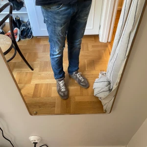 Blå Replay jeans med slitningar - Säljer ett par blå Replay jeans med snygga slitningar och distressed detaljer. Jeansen har klassisk femficksdesign, normal passform och raka ben. Materialet är mjukt och stretchigt för extra komfort. Perfekta för dig som gillar en avslappnad och trendig look. Hör av er om ni har några frågor eller funderingar!