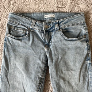 Ljusblå bootcut jeans från Gina - Snygga ljusblå jeans från Gina Tricot med klassisk femficksdesign och bootcut-ben. Jeansen har låg midja och är gjorda i mjukt denimtyg. Bakfickorna har lock och knappdetalj. Pris kan diskuteras och skriv för mått eller fler bilder