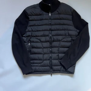 Moncler Cardigan Svart - Hel! Säljer en äkta Moncler Cardigan då den har blivigt lite för liten för mig. Haft den sedan slutet av sommaren. Knappt använd och har fortfarande bra kvalitet. Storleken är L men sitter som M (42-47) DM om intresserad. 