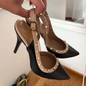 Svarta pumps med nitar och beige rem - Snygga svarta pumps med spetsig tå och hög klack. Storlek 37, klack 5/6 cm 