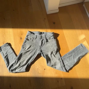 Replay Anbass grå jeans slim fit - Säljer ett par grå Replay Anbass jeans i slim fit med klassisk femficksdesign och snygga detaljer på bakfickorna. Jeansen har en något tvättad look och är tillverkade i mjukt bomullsmaterial med lite stretch för extra komfort. De är endast använda ett fåtal gånger.                                             Vid frågor hör av er.
