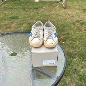 Golden Goose Superstar sneakers vit/blå - Säljer ett var vita Golden Goose med blå stjärna! Sparsamt använda med tecken av användning. Men redo att ge mer!