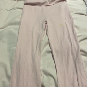 Ljusrosa bootcut mjukisbyxor - Ljusrosa mjukisbyxor med bootcut-ben och låg midja. Byxorna är tillverkade i mjukt bomullsmaterial och har en avslappnad passform. Perfekta för en chill och bekväm stil.