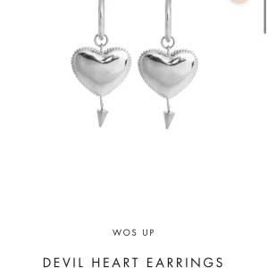 WOS UP Devil Heart örhängen silver - Snygga örhängen i silverfärg från WOS UP med hjärtformade hängen och små spetsiga detaljer undertill. Ger en edgy vibe med sin coola design och passar perfekt för dig som vill sticka ut lite extra.