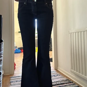 Lågmidjade mörkblå jeans - Säljer dessa jätte snygga lågmidjade utsvängda jeans från Design by Si. De är endast testade så i nyskick! Beninnerlängden är ca 87cm och för referens är jag 172/173cm så de passar längre personer. Storlek S💗
