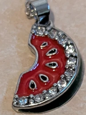 Halsband med vattenmelon-hänge - Sött halsband med ett hänge format som en vattenmelon. Hänget är rött med svarta kärnor och har en glittrig kant. Kedjan är i silverfärg och passar perfekt för dig som gillar färgglada accessoarer.