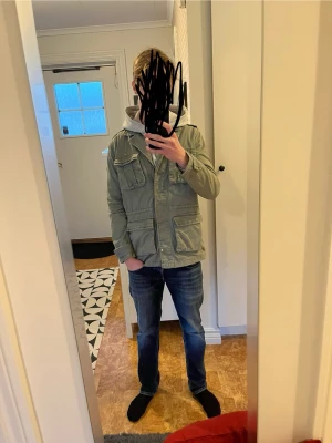 Monki feild jacket - Säljer en grön parkajacka från Monki med klassisk krage och flera stora fickor framtill. Jackan har lång ärm och knappar längs framsidan. Perfekt för dig som gillar en chill och enkel stil.