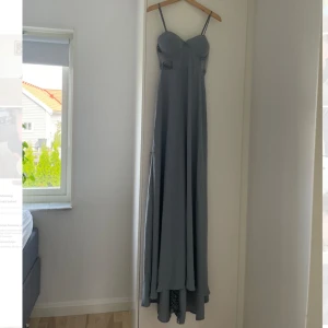 Klänning - Supefin klänning, perfekt till bal eller som brudtärna.      Aldrig använd, lapparna sitter kvar. Hittar några defekter på klänningen, där små trådar har gått upp.  Inbygd bh, för stor för mig som vanligtvis bär 75B. 