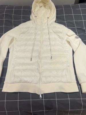 Moncler cardigan vit - En snygg stilren vit moncler cardigan jacka som har blivit lite liten på mig nu, den är mycket grisch och orten stil. Det är en damstorlek L, då den skulle passa dig som är 170cm och mindre, den är i mycket bra skick och väl handomtagen, dm för mer info !! MYCKET BRA PRIS !!