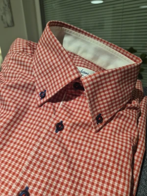 Rutig röd skjorta från Stenströms - Säljer en snygg röd och vit rutig skjorta från Stenströms, modell Fitted Body. Skjortan har mörkblå knappar med röda detaljer och klassisk krage med vit insida. Tillverkad i mjuk och exklusiv bomull som känns riktigt skön mot huden. Perfekt för dig som gillar stilrena detaljer.