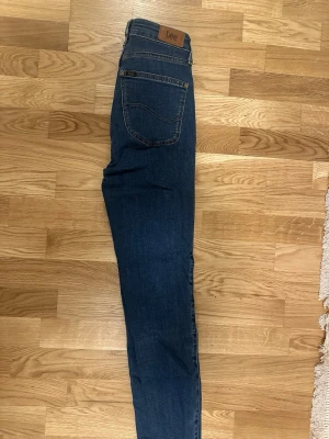 Mörkblå skinny jeans från Lee - Säljer ett par mörkblå skinny jeans från Lee hög midja. Stretchigt material. Skriv för mer info!