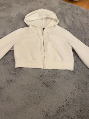 Cropped hoodie - Vit cropped hoodie med dragkedja och snören. Kan eventuellt tänka mig gå ner i pris