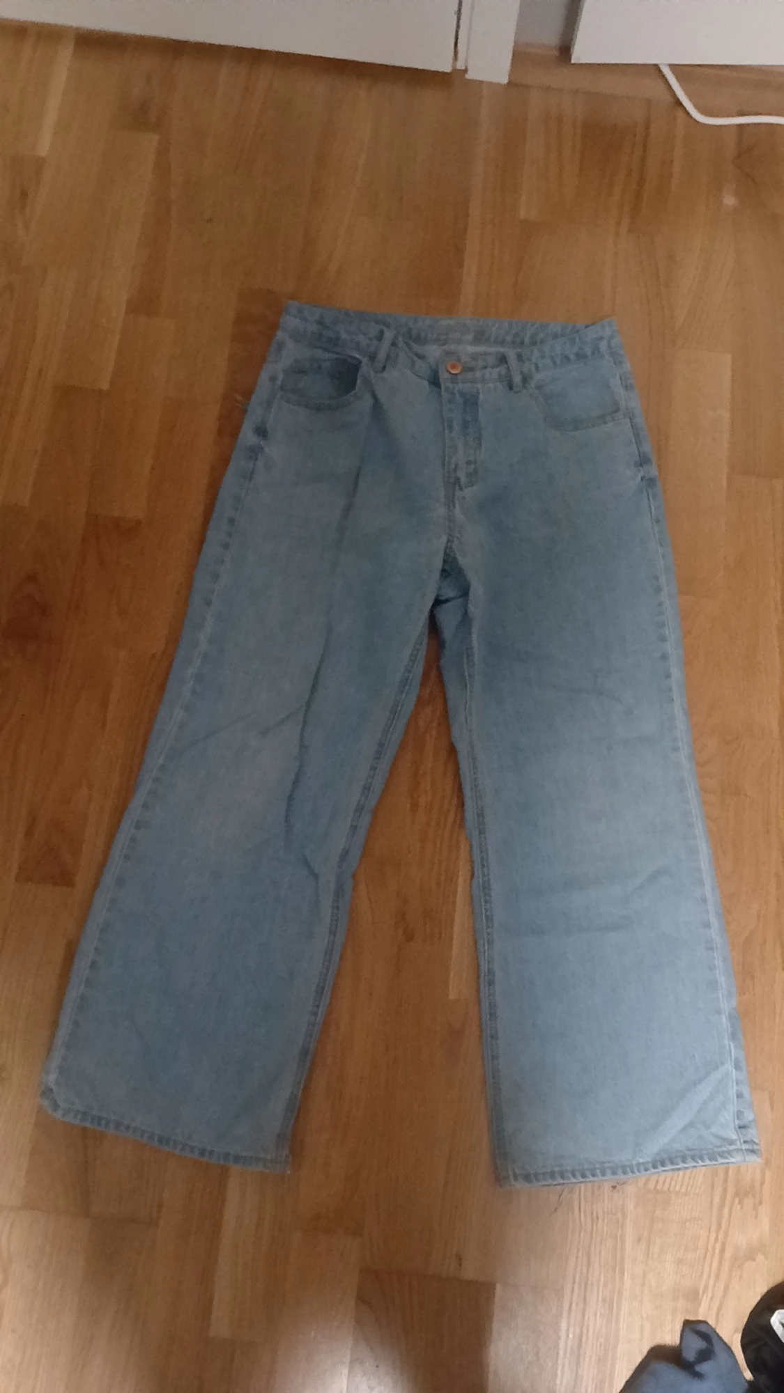 Ljusblå wide jeans med trasig ficka