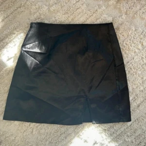 Svart kortkjol med slits - En fin silkes minikjol med ett litet slitt, jätte fin har tyvärr inte kommit till användning. Endast använd 2-3 gånger, 