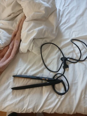 BaByliss iPro 230 lon hair Straightener - Svart plattång med keramiska plattor och lång sladd. Plattången är i gott skick utan synliga repor eller skador. Perfekt för att snabbt och enkelt styla håret hemma. Enkel att använda med smidig design.