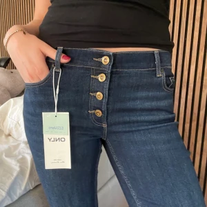 Low waist bootcut jeans  - Så snygga jeans med coola och unika knappar och detaljer!! Prislapp kvar!!😍😍💕💕 innerbenslängd: 85cm, midja: 36cm