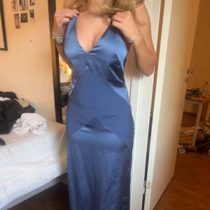 Blå långklänning i satin från H&M - Blå långklänning från H&M i glansig satin i storlek 34. Även en slits vid sidan🥰🥰