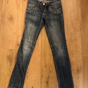 Blå jeans med nitar från WeTweens - Snygga blå jeans med coola nitar på både fram- och bakfickor. Modellen är rak/smal och har snygg ficksdesign med knapp och dragkedja. Den är strl 152, men tror att den passar xxs - xs också. Pris går att diskuteras!