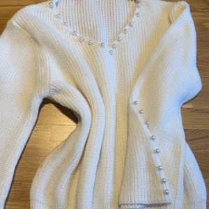 Vit stickad tröja med pärlor - vet ej vart den är ifrån