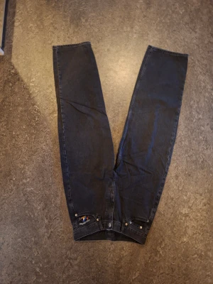  universal svarta raka jeans - Säljer svart tv sopade lead jeans från Universal med raka sopade ben och klassisk femficksmodell. Broderad logga på TV sopade bakfickan. Perfekta för en avslapp letad streetstil cl expose.