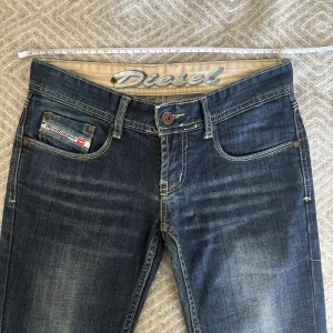 Lågmidjade Diesel jeans med bootcut - Ett par dieseljeans i mörkblått som ser nästan oanvända ut! Storleken säger w26 men skulle skulle säga att de är en w25  Midjemått: 35cm  Innerbenslängd: 70cm  Skriv vid funderingar!💗