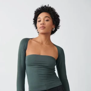 Mörkgrön långärmad tubtopp - Säljer en mörkgrön tubtopp med långa ärmar och axelbandslös design. Aldrig använt den endast testad. Köptes för 259❤️Passar S