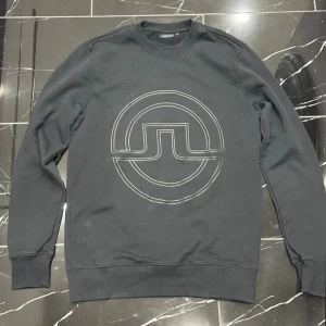  J.Lindeberg Tröja - Stilren svart tröja ifrån J.Lindeberg i storlek M. Den har nästan aldrig använts så den är i princip i helt nytt skick. Inga defekter. 