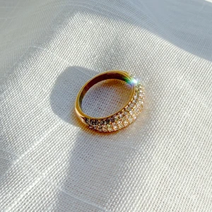 Ring i rostfritt stål med 18k guldplätering och cubic zirconia stenar - Snygg guldfärgad ring med glittrande cubic zirconia stenar. Rostfritt stål med 18 karat guldplätering. Storlek 7 (17,3 mm)