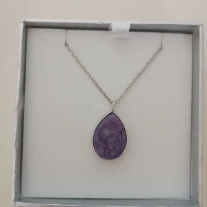 Halsband med ametist  - Oanvänt silver halsband med ett ametisthänge, kedjans längd är ca. 80 cm.