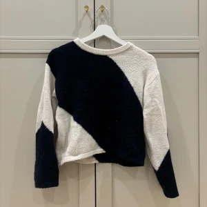 Svartvit stickad tröja Gina Tricot - Säljer en stickad tröja från Gina Tricot i storlek 146/152. Tröjan har ett coolt, grafiskt mönster i svart och vitt med breda diagonala fält. Rund hals med ribbad kant och långa ärmar. Perfekt för vintern,💕
