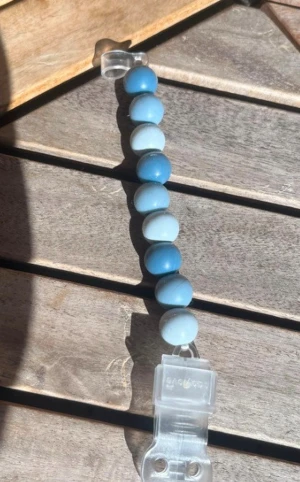 Blått nappband med stora pärlor - Snyggt nappband med stora runda pärlor i olika blå nyanser, från ljusblått till mörkare blått. Pärlorna är trädda på en elastisk tråd och armbandet har en enkel, stilren look som passar till många outfits.