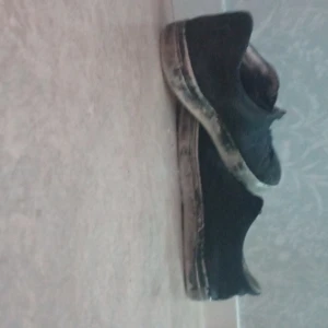 Svarta sneakers med vit sula - Svarta sneakers med låg profil och vit sula. Skorna har en klassisk rund tå och platt sula, vilket gör dem enkla att matcha till olika outfits. Perfekta för dig som gillar en stilren och avslappnad look.