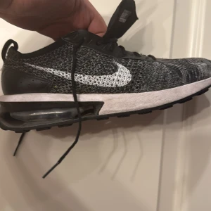 Nike Air Max Flyknit svart/vit - Säljer ett par Nike Air Max med Flyknit-överdel i svart och vitt. Skorna har en stickad ovandel, synlig Air Max-dämpning i sulan och klassisk vit Swoosh på sidan. Perfekta för dig som gillar sportig stil och vill ha riktigt sköna sneakers med snygg design. Köpte den för 2000kr helt ny oanvänd äkta 