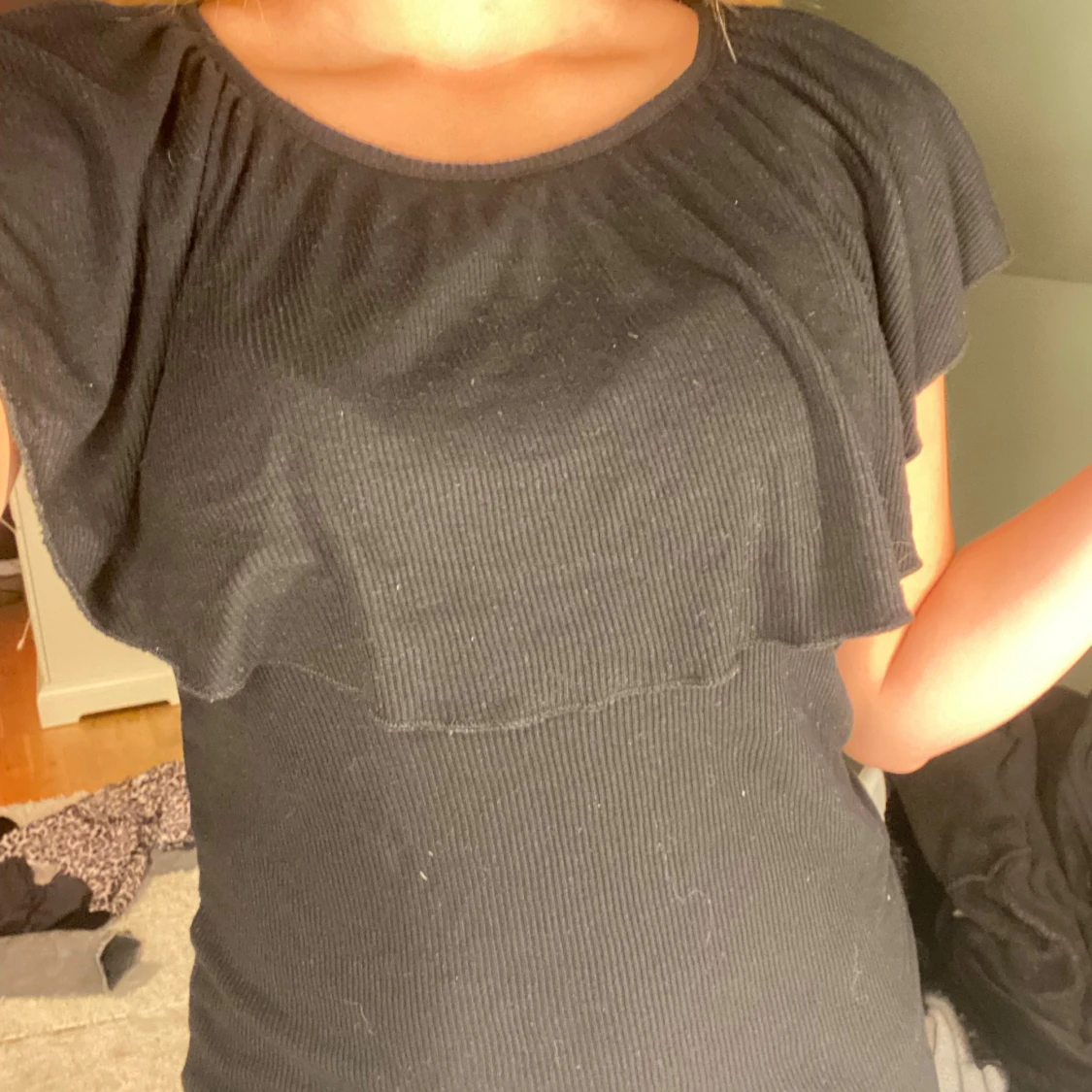 Svart ribbad topp med volang - 1