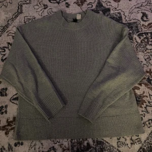 stickad tröja - Mysig grå stickad tröja från Divided med rund halsringning och breda ribbade muddar vid ärmslut och nederkant. Perfekt för lager-på-lager och chill dagar. Enkel och stilren design som funkar till allt.