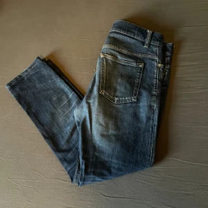 Filippa K jeans - Snygga jeans från Filippa K. Rob i klassisk blå tvätt. Modellen har raka ben, fem fickor och normal/slim passform. Perfekta för dig som gillar en stilren look med diskreta slitningar och bekvämt material. Står 33/32 men passar mig som har 31/32. Nypris 1399:-. Mitt pris 299:-. Hör av dig vid minsta lilla fråga😊 4 nya plagg ligger ute!