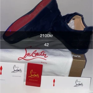  Louboutin - Säljer ett par mörkblå sneakers från Christian Louboutin med klassisk röd sula. Skorna har en stilren design med rund tå och är tillverkade i mocka. Perfekt för dig som gillar exklusiva märken och vill sticka ut med en lyxig detalj.