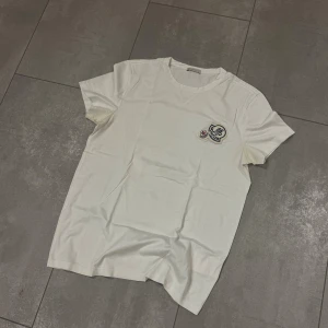 Moncler Double Logo T-Shirt  - Yoo, säljer denna t-shirt ifrån Moncler, den har ett litet hål i magen som du kan se på bild 3. Hålet går att sy ihop om man är duktigt eller lämnar in den hos en skräddare. Har även lite Deoflöckar men inget som inte går bort! Kan gå ner i pris vid smidig affär 